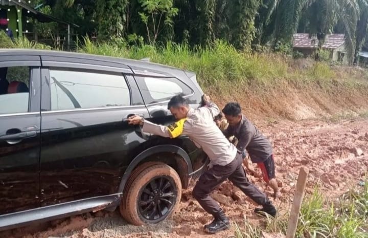 Warga lagi Kesusahan, Bhabinkamtibmas Ini Bantu Dorong Mobil Warga Yang Terbenam Dalam Lumpur